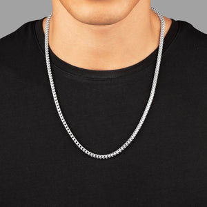a close view of a man in a black shirt wearing a 4mm silver franco chain
