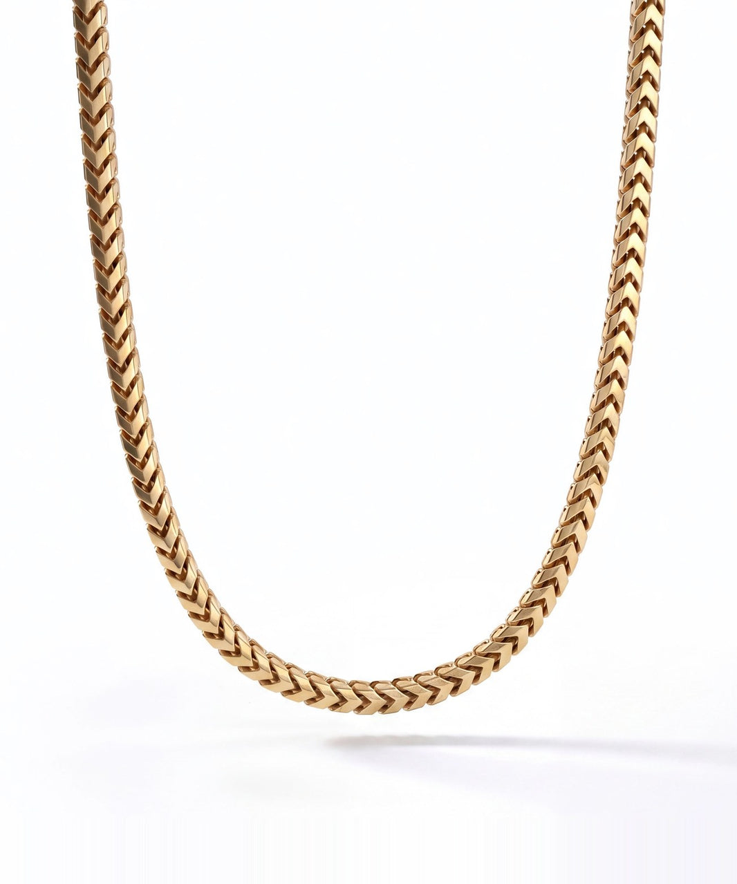 A solid yellow gold 4mm Franco chain hanging against a white background