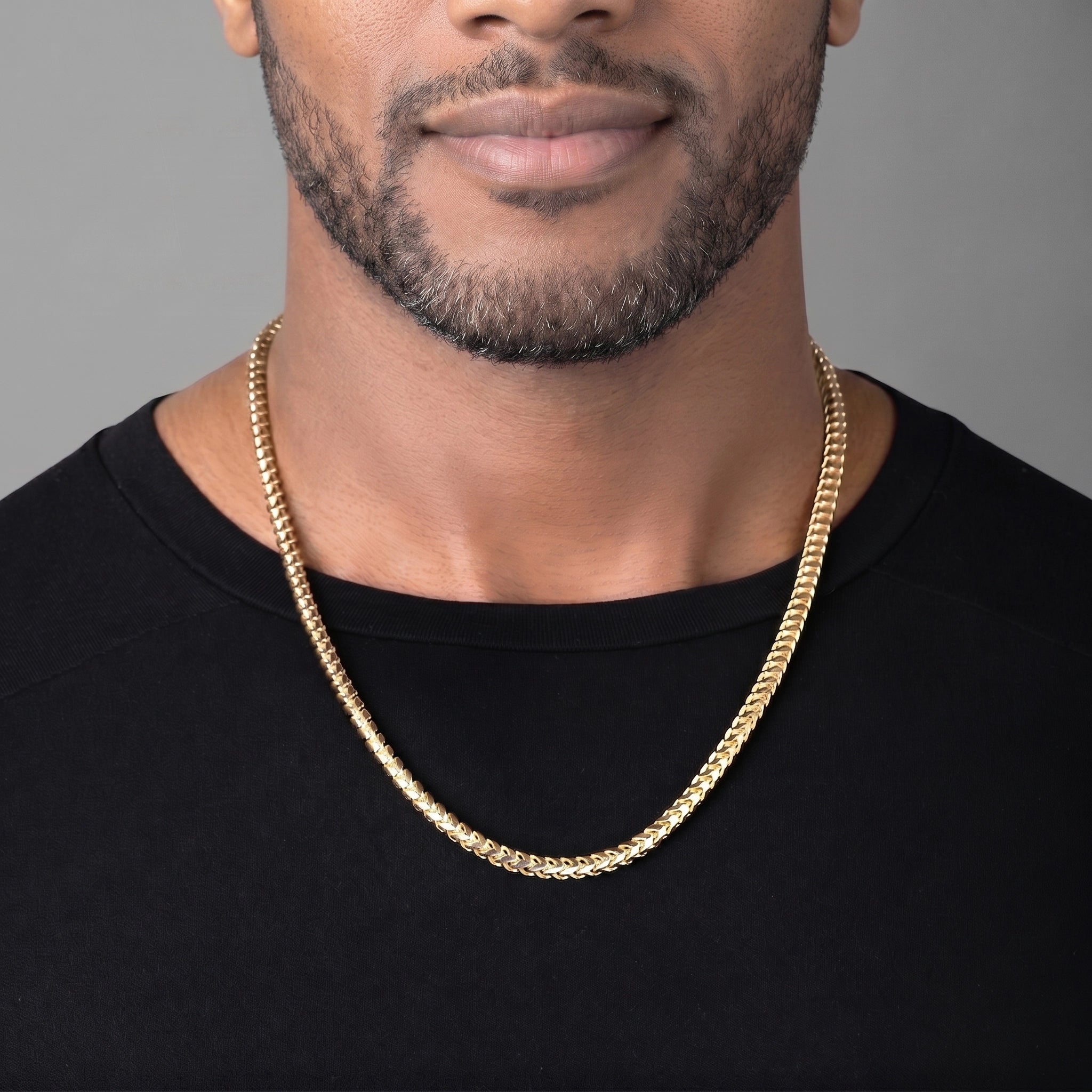 5mm Diamond Cut Franco Chain, 14k Yellow Gold worn by a man in front of a gray background