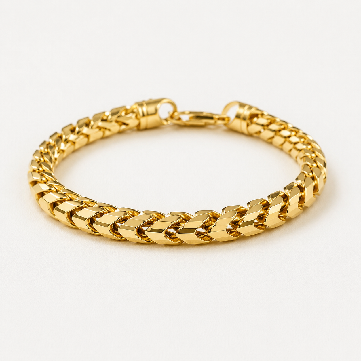 6.5mm Diamond Cut Franco Bracelet, 18k Yellow Gold lays on a white surface