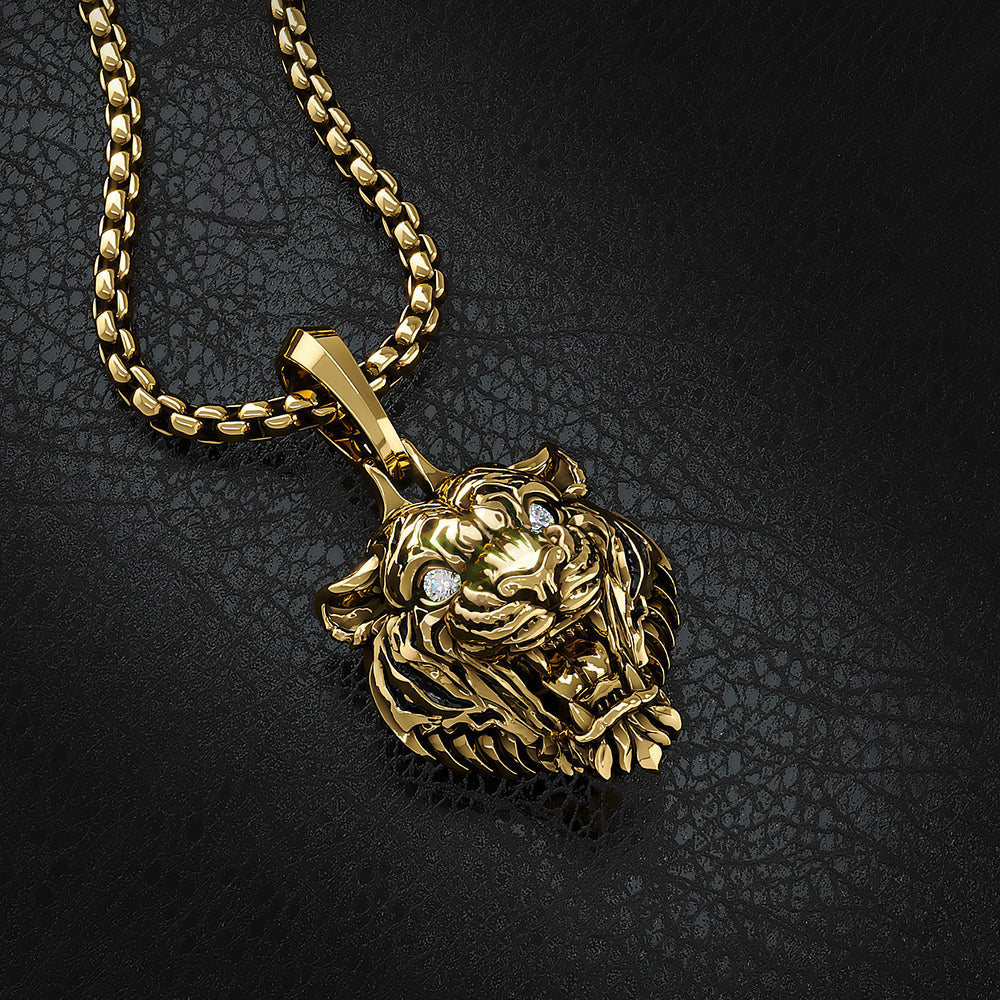 a 14 karat gold tiger pendant lays on a black leather surface