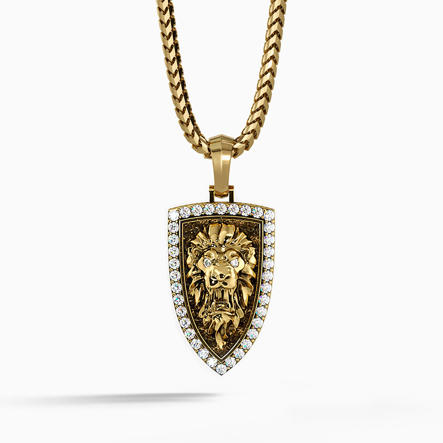 a gold lion head pendant is sculpted into the shape of a shield with diamonds around the border