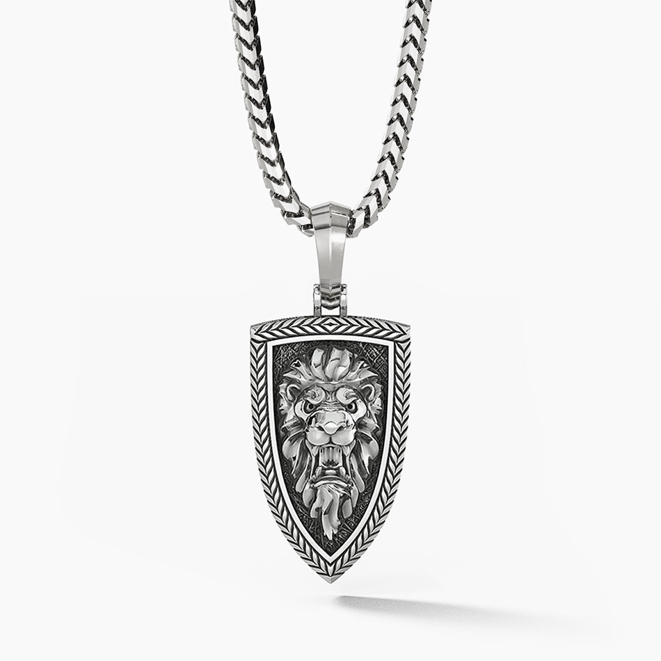 a silver lion head pendant is sculpted into the shape of a shield