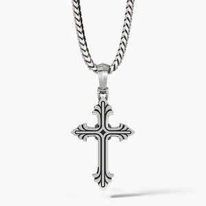 a sterling silver cross necklace hangs from a chain