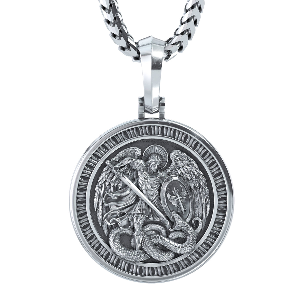A silver-toned round pendant necklace featuring an embossed relief of Saint Michael with wings and a sword fighting a serpent, suspended from a thick curb chain against a plain white background.