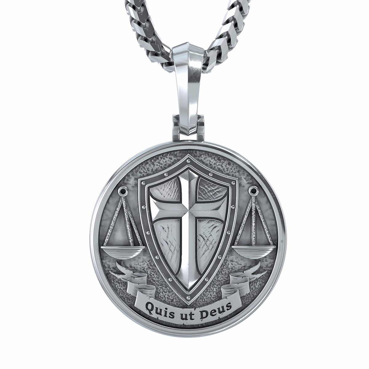 A silver-toned round pendant necklace featuring a shield with a cross, balanced scales, and the engraved text 'Quis ut Deus' on a white background.