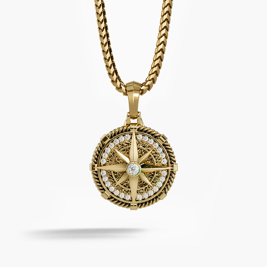 a detailed gold compass pendant with diamonds hangs from a silver chain
