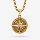 Gold Compass Pendant with a bezel set diamond in the middle hangs on a white background
