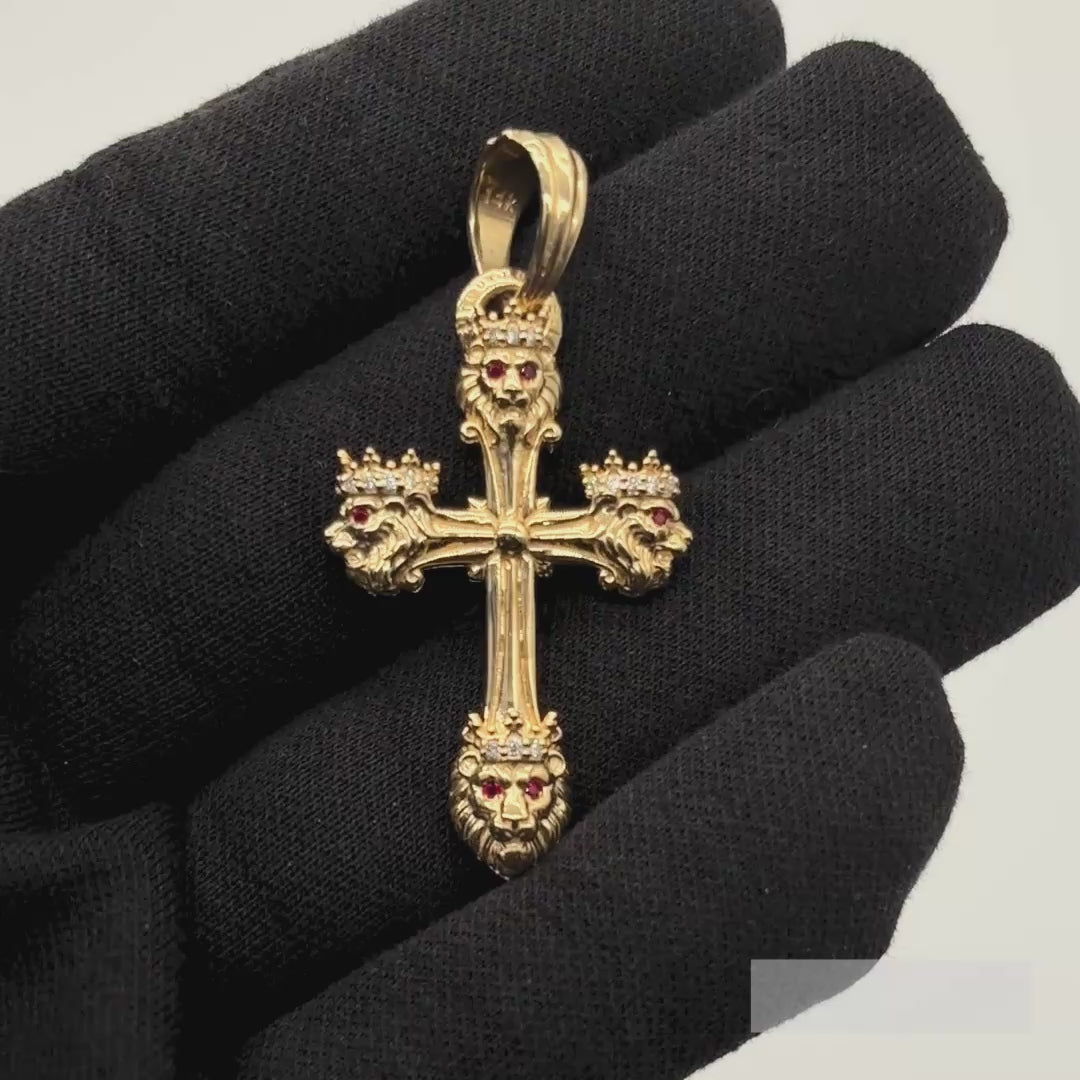 A solid gold lion pendant with ruby eyes and diamond crown is shown in hand