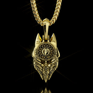 The back of a gold wolf pendant features a dreamcatcher