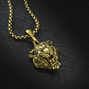 a 14 karat gold tiger pendant lays on a black leather surface