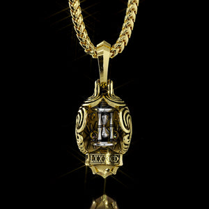 the back of a gold skull necklace features a spinning hourglass