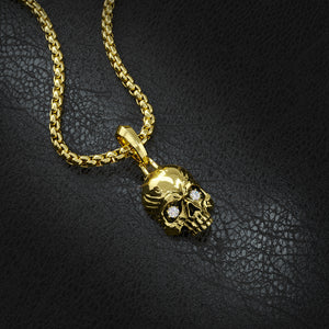 a diamond skull pendant made from solid 14k gold lies on black leather