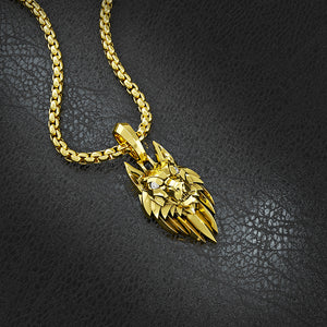 a gold wolf necklace lies on slate with a 14 karat crown ring