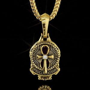 the back of a gold skull pendant features a ankh design with a diamond