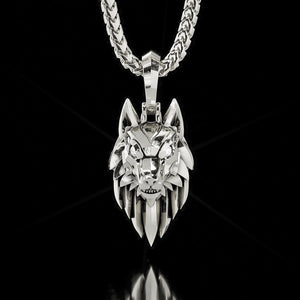 A white gold wolf pendant with diamonds hangs from a franco chain on a black background