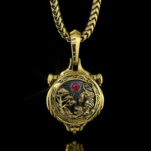 the back of a gold tiger pendant features a red diamond and a sculpted scene of trees and the sun