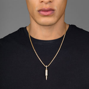 a man in a black shirt wearing a gold bullet pendant with diamonds hanging from a 3mm franco chain