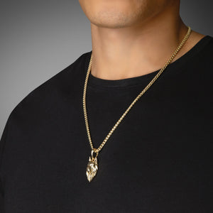 a man in a black shirt wears a sculpted gold wolf pendant with diamond eyes