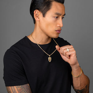 an active man in a black shirt wears a mens diamond wedding band and lion necklace