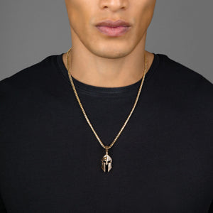 a man in a black shirt wearing a gold Spartan pendant with diamonds hanging from a 3mm franco chain