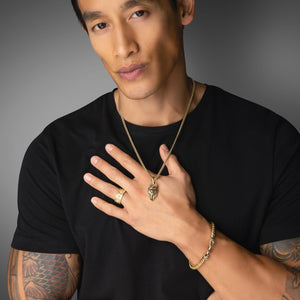 an active man in a black shirt wears a gold crown ring and wolf necklace with diamond eyes