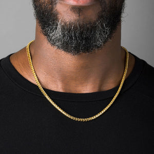 a man in a black shirt wearing a 4mm diamond cut franco gold necklace for men