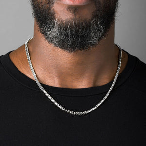 a man in a black shirt wearing a 4mm diamond cut franco white gold necklace for men