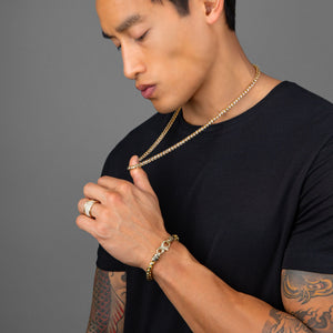 a up close photo of a man with tattoos wearing a gold 4mm prism cut franco chain