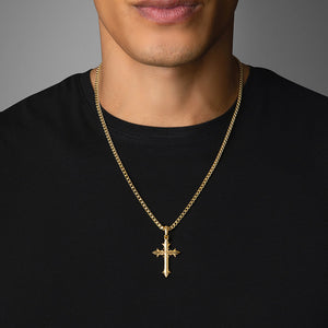 a man in a black shirt wears a small gold cross pendant