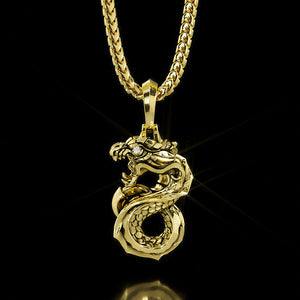 A fierce gold dragon pendant hangs on a gold necklace