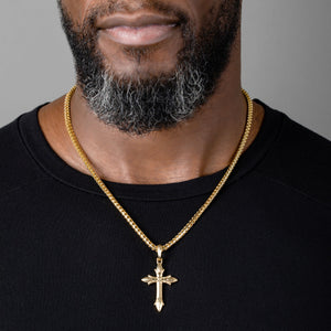 man wears a large gold cross necklace and franco chain