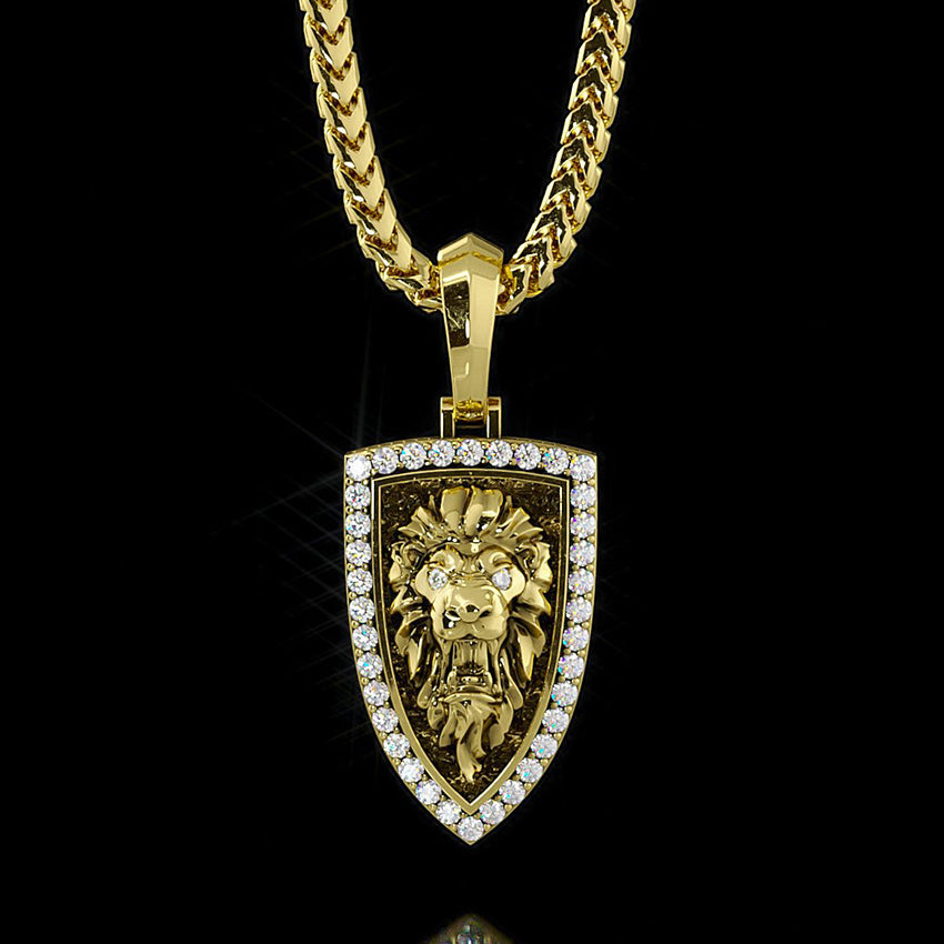 a gold lion head pendant is sculpted into the shape of a shield with diamonds around the border
