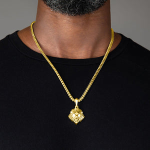 a large gold lion head pendant hangs from a man's franco chain