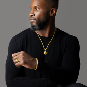 a man wears a polished yellow gold lion pendant and matching gold bracelet