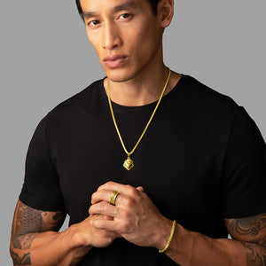 a man in a black shirt wears a gold lion pendant