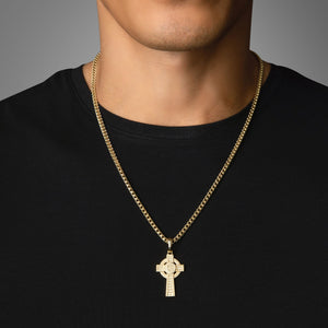 a man in a black shirt wears a Celtic gold cross pendant