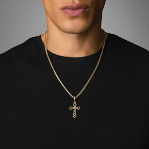 a man in a black shirt wears a small gold cross pendant