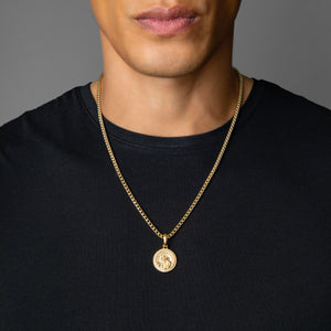 a man wearing a gold Saint Christopher pendant on a franco necklace