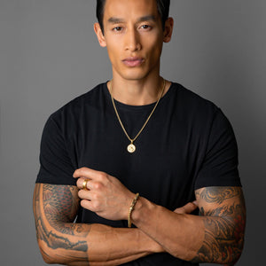 stylish man wearing a gold Saint Christopher necklace on a 14k gold chain