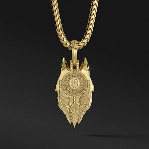 The back of a gold wolf pendant features a dreamcatcher