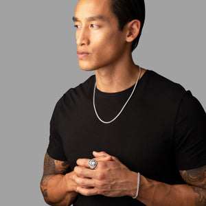 man with asian tattoos looking away as he wears a silver franco necklace and bracelet set