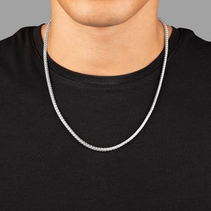 a close view of a man in a black shirt wearing a 3mm silver franco chain