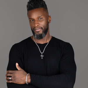 a sterling silver cross necklace is worn by a muscular man with a black shirt