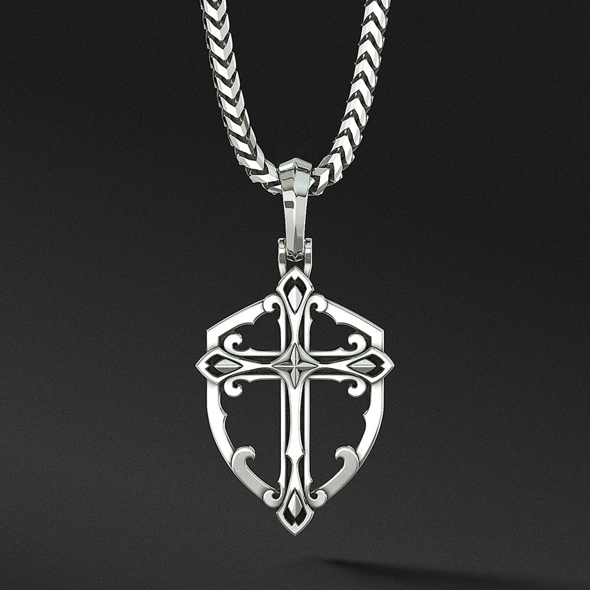 a sterling silver cross necklace in the shape of a shield hangs from a chain