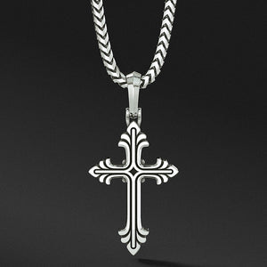 a sterling silver cross necklace hangs from a chain
