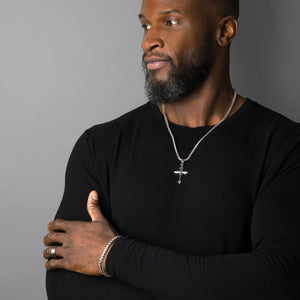 a sterling silver cross necklace is worn by a muscular man with a black shirt