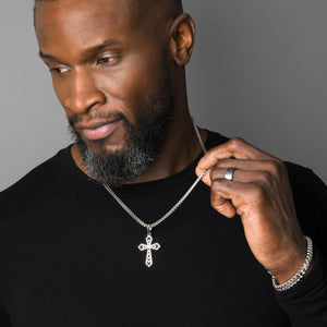 a sterling silver cross necklace is worn by a muscular man with a black shirt