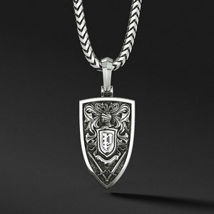 The back of a silver lion pendant features a royal pattern and swords