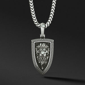 a silver lion head pendant is sculpted into the shape of a shield